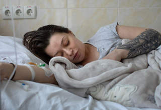 Анастасія відпочиває в пологовому будинку з новонародженим сином Яном 28 квітня 2022 року в Кишиневі, Молдова. © UNFPA/Зігфрід М