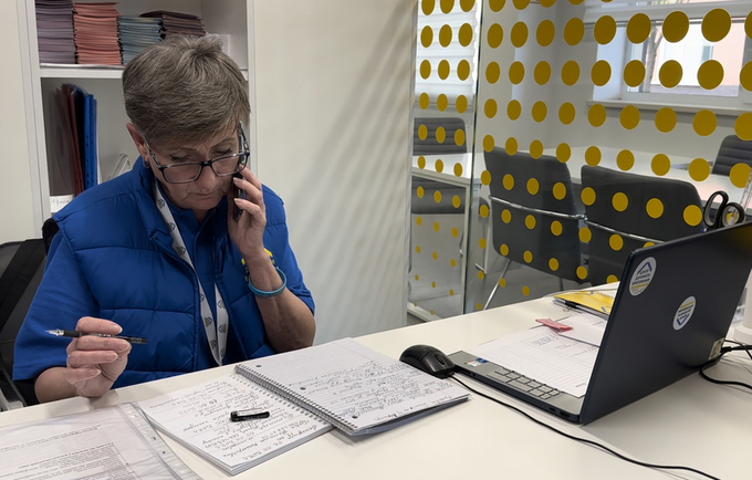A woman in the uniform of an employee of the Survivor relief Centre in Odesa communicates with clients on the phone