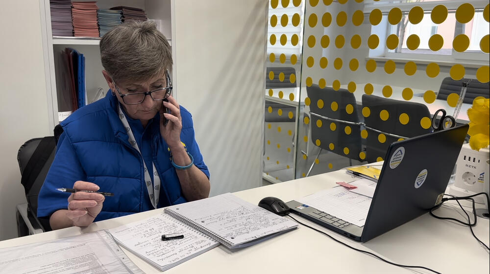 A woman in the uniform of an employee of the Survivor relief Centre in Odesa communicates with clients on the phone